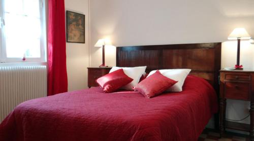 La Neuville-du-BoscGite de la Haute Verdière的一间卧室配有红色的床和两个红色和白色枕头