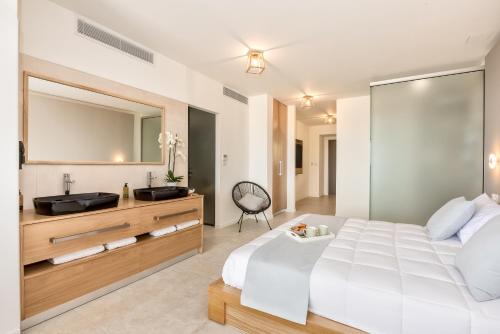 埃亚玛琳娜奈奇多Lilium Luxury Suites的卧室配有白色大床和水槽