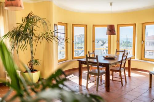 佩尼契Peniche Beach House的一间带桌椅和窗户的用餐室