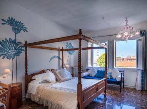 穆拉诺卡萨苏拉拉古纳旅馆的一间卧室设有一张天蓬床和大窗户