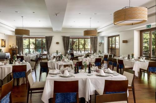 格拉纳达格拉纳达旅馆的餐厅设有白色的桌椅和窗户。