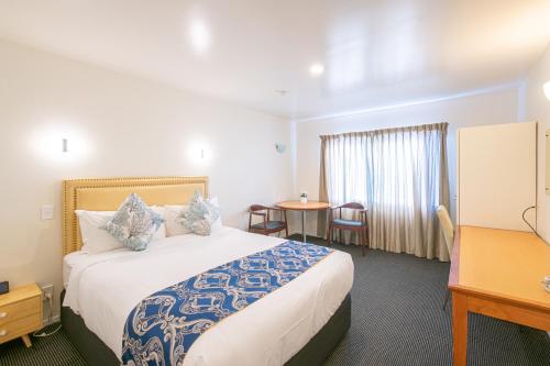 奥克兰奥克兰新市场汽车旅馆的酒店客房设有一张大床和一张桌子。