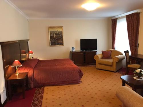 克莱佩达商会宾馆的酒店客房配有一张床、一把椅子和一台电视。
