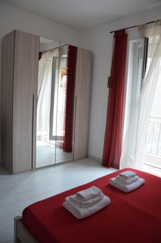 卡诺萨迪普利亚Casa di marco2的一间卧室配有红色的床和镜子