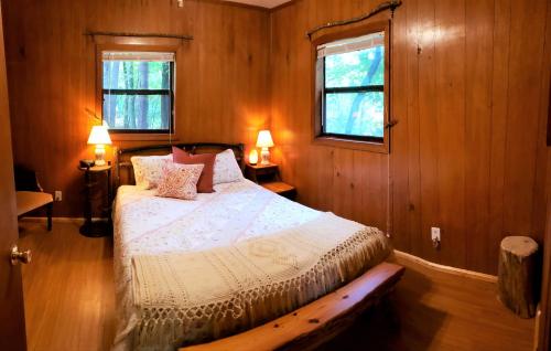 海伦Mountain Laurel Cottage at Hearthstone Cabins and Camping - Pet Friendly的卧室配有床,位于带2个窗户的房间
