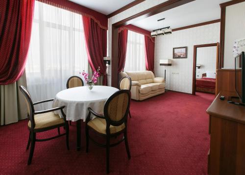卡马河畔切尔尼鞑靼斯坦共和国商务酒店的一间带桌椅的房间和一间卧室