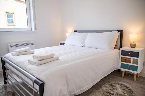 因弗内斯Millburn Apartment的卧室配有带毛巾的大型白色床