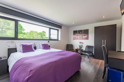 莫尔莫门托住宿加早餐旅馆的一间卧室配有一张大紫色床和一张书桌
