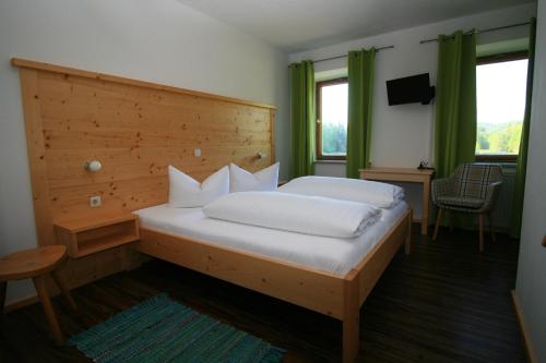 埃尔森贝格Landgasthof Auerschmiede的一间卧室配有一张大床和木制床头板