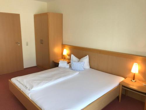 斯特滕阿卡顿玛洛斯勒酒店的一间卧室配有一张带两盏灯的大型白色床。