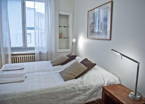 赫尔辛基Helsinki Apartments的一间卧室配有带白色床单和枕头的床。