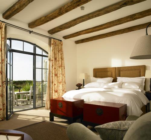 敦贝格Trump International Golf Links & Hotel Doonbeg Ireland的一间卧室设有一张床和一个滑动玻璃门