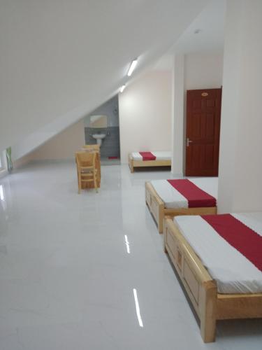 大叻Mango Hotel Dalat的客房设有两张床和一张书桌
