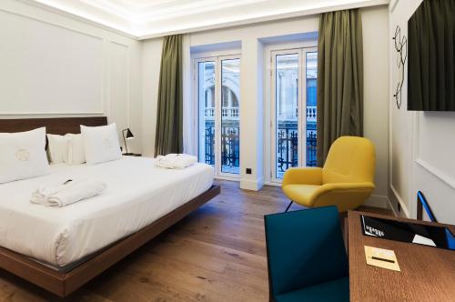 瓦伦西亚维多利亚女王宫殿4号体验酒店的酒店客房,配有床和黄色椅子