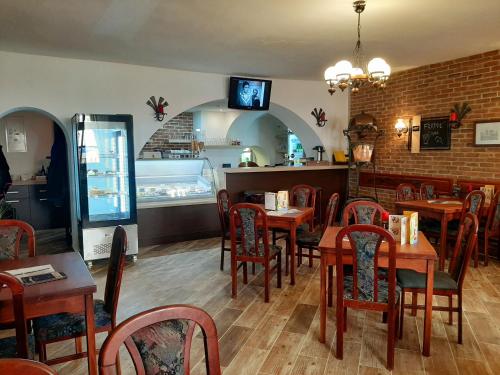 泰普拉河畔贝乔夫Penzion - Restaurant U Zámku的餐厅内带木桌和椅子的用餐室