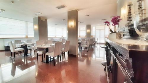 利尼亚诺萨比亚多罗弗拉伊皮尼酒店及健康中心的餐厅内带桌椅的用餐室