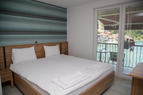 奥赫里德Villa Marko - Trpejca的一间卧室设有一张床和一个阳台