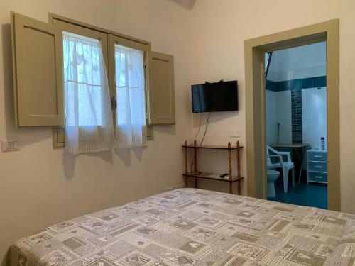 圣切萨廖迪莱切I due Tesori的一间卧室设有床、两个窗户和一台电视