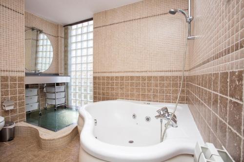 萨洛Alojamiento Villa Moles的带浴缸和盥洗盆的浴室