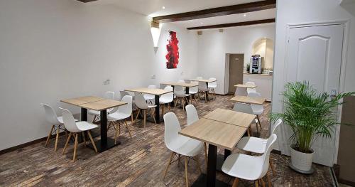 第戎查姆贝兰酒店的一间设有木桌和白色椅子的房间