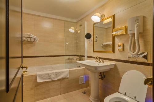 斯纳戈夫史纳高俱乐部度假村的浴室配有卫生间、盥洗盆和浴缸。