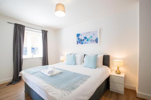霍兹登Velvet 1-bedroom apartment, Clockhouse, Hoddesdon的一间卧室配有一张带蓝色枕头的大床