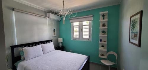 伊莎贝拉Palmeras Del Mar的卧室配有白色的床和绿色的墙壁