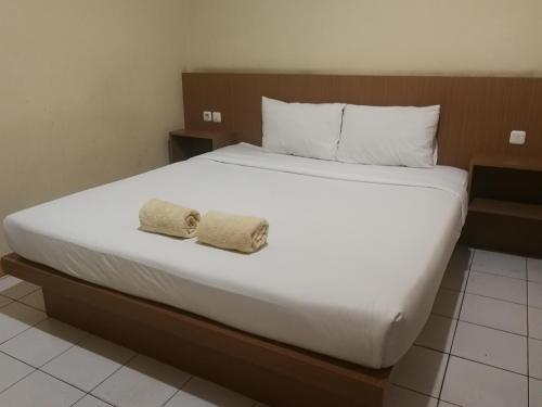 占碑市Hotel Mayang Sari 2的一间卧室配有一张大床和两条毛巾
