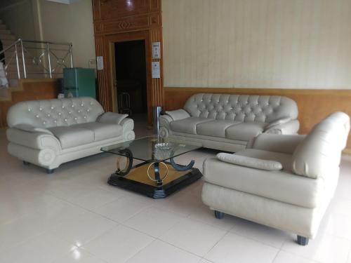 PaalmerahHotel Formosa Jambi的客厅配有两张沙发和一张咖啡桌