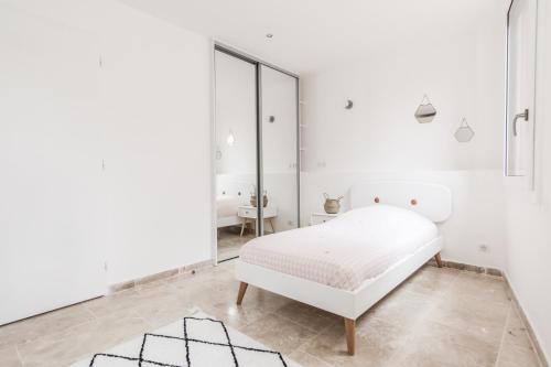 卡西斯LOCAPPART CASSIS en Provence的白色卧室配有床和镜子