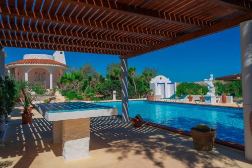 兰佩杜萨奥斯卡萨布兰卡酒店的一座带木制凉亭的游泳池的房子