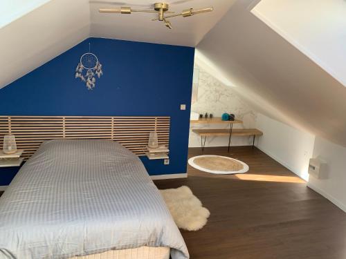 勒蒙多尔Duplex plein centre ville 3Etoiles的一间卧室设有蓝色墙和一张床