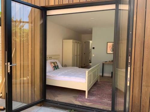 赞德沃特Charming private guesthouse Air by the Beach的玻璃门内有一张床的房间