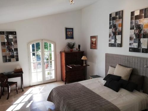 Bourg-CharenteLe Domaine Des Platanes的一间卧室配有一张床、一张书桌和一个窗户。