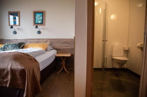 Skálafell斯米尔拉柏格酒店的一间卧室配有一张床和一个卫生间
