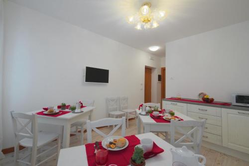 威尼斯Palazzetto Canossa的厨房配有白色桌子和白色椅子,并备有食物