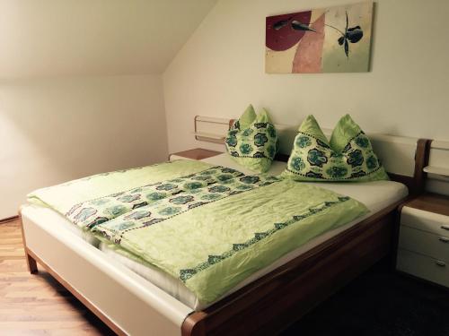 阿特湖Das Ferienhaus的一间卧室配有一张带绿床单和枕头的床。