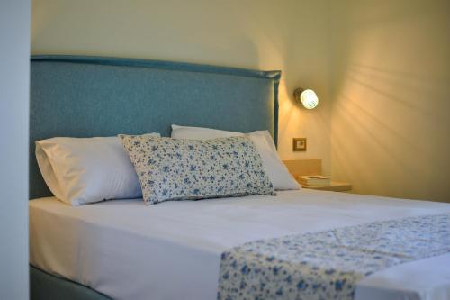 特拉佩扎奇Liogerma Studios的一张带蓝色床头板和白色枕头的床