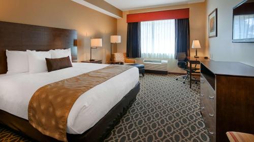 萨沃伊天堂贝斯特韦斯特酒店 的酒店客房设有一张大床和一张书桌。
