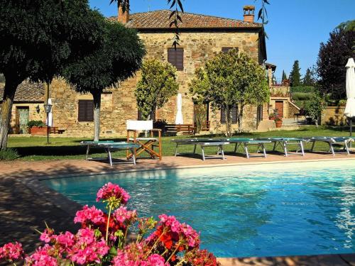 皮恩扎卡萨尔皮亚诺农庄酒店的一座带长椅和鲜花的建筑前的游泳池