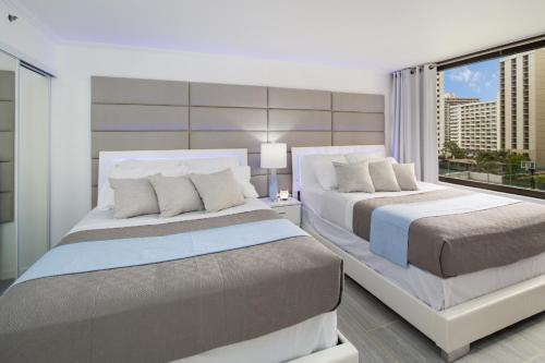 檀香山Waikiki Banyan Modern One Bedroom Free Parking的一间卧室设有两张床和大窗户