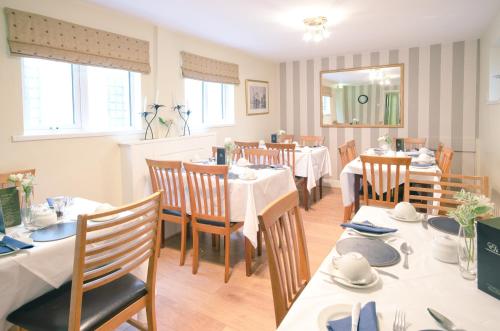 班戈北爱尔兰Ennislare House Guest Accommodation的一间设有白色桌椅的用餐室