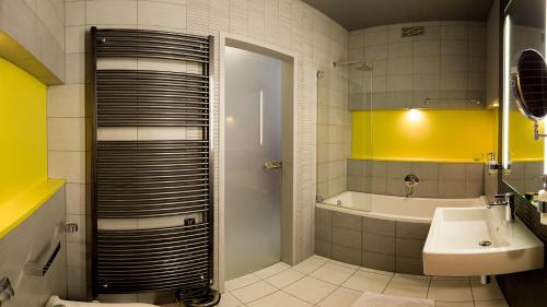 波普拉德Hotel AquaCity Mountain View的带淋浴、盥洗盆和浴缸的浴室