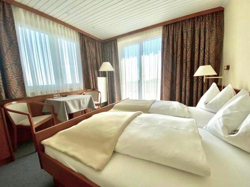 Sankt Radegund bei Graz赛锐膳食公寓酒店的酒店客房设有两张床和一张桌子。