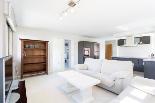 米尼奥Housingcoruña Apartamento Playa Miño 03的客厅配有白色的沙发和桌子
