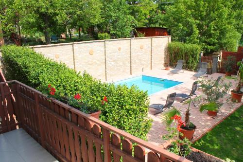 福纽德Ibolya Apartmanok的后院设有游泳池和围栏
