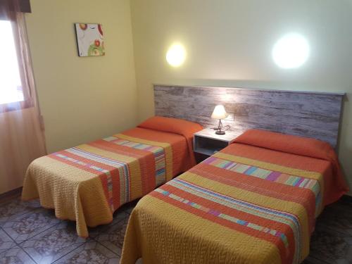 隆达圣女罗西奥旅馆的酒店客房,设有两张床和一盏灯