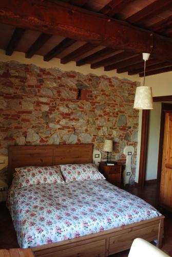 圣朱利亚诺-泰尔梅Podere San Paolo的一间卧室设有一张床和石墙