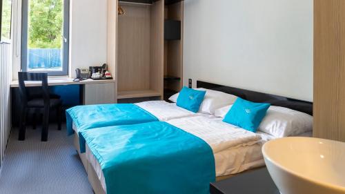 波普拉德水城滨江酒店的酒店客房配有一张带蓝色枕头的大床