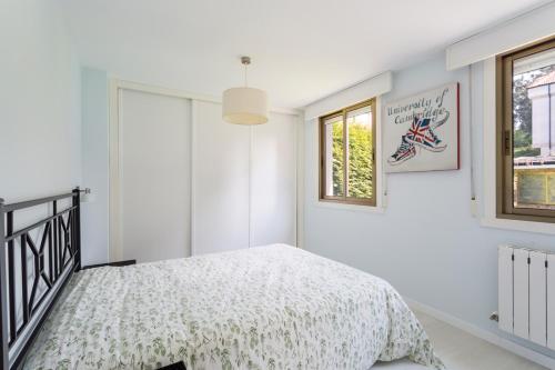 米尼奥Housingcoruña Apartamento Playa Miño 02的白色的卧室设有床和窗户